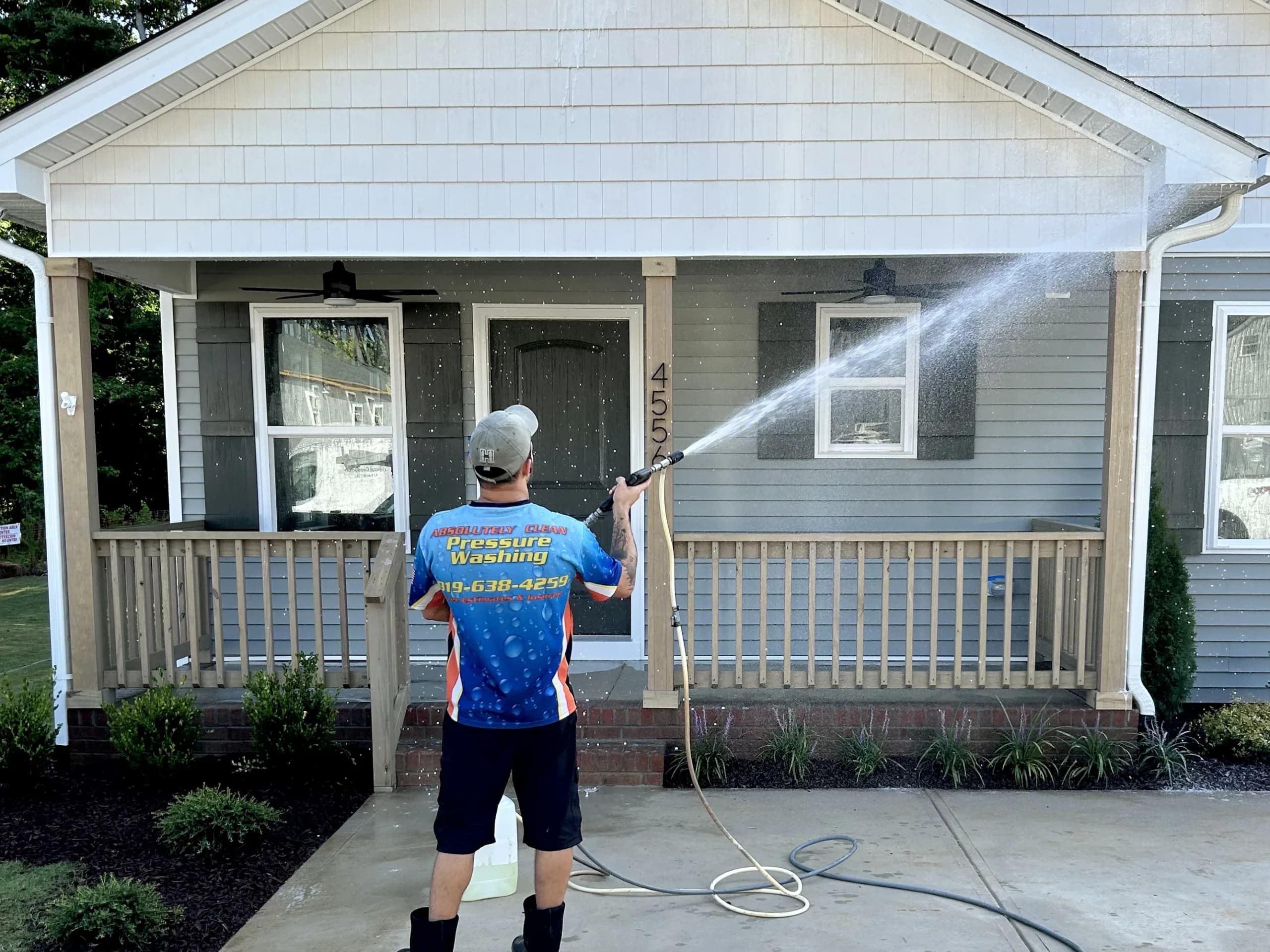 An Absolutely Clean team member washing the exterior of a Triangle home